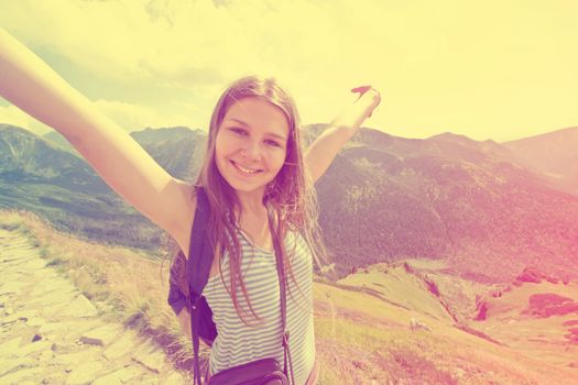 Happy teenage girl feel freedom in mountains scenery. Vintage instagram picture.