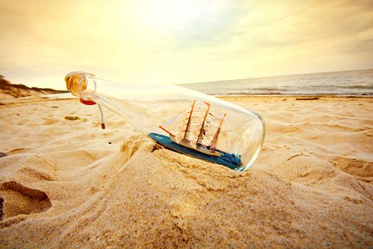 Ship in the bottle lying on the beach. Souvenir conceptual image. Nature in paradise.