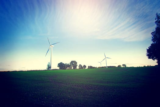 Windmills on the field. Alternative ecological energy. Instagram vintage dark picture.