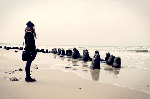 Emotion conceptual image. Sad lonely woman on the beach. Instagram vintage picture.