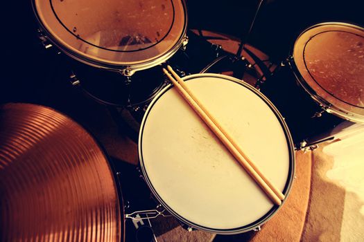 Drums conceptual image. Picture of drums and drumsticks lying on snare drum. Retro vintage instagram picture.