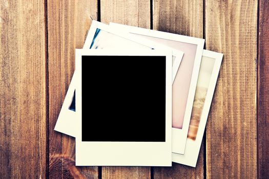 Instant blank photos frame on wooden background. Free copyspace. Vintage retro.