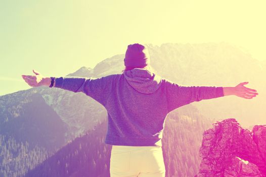 Teenage girl feel freedom in mountains scenery. Vintage instagram picture.