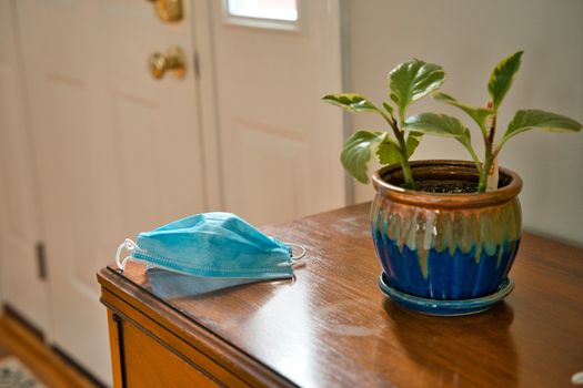 Mask on table looking towards door. Using mask as protecting from coronavirus to flatten the curve