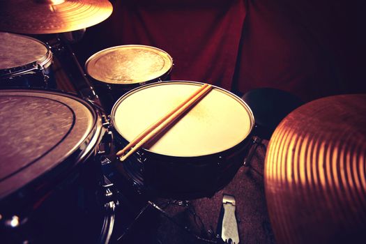 Drums conceptual image. Drums and drumsticks lying on snare drum. Retro vintage instagram picture.