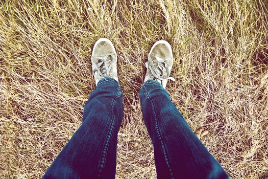 Teenage hipster legs on grass. Instagram vintage picture.