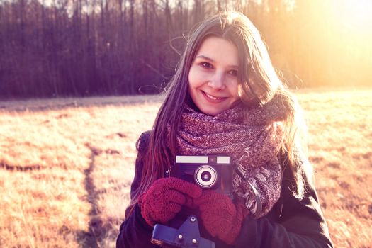 Young hipster girl with retro vintage camera. Instagram vintage picture.