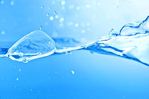 Water splash and air bubbles. Blue background.