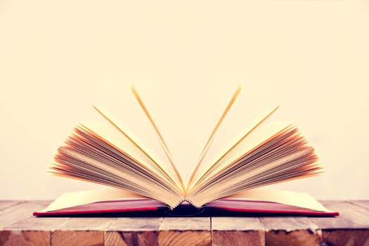 Open book on wooden table and white background. Education conceptual image.