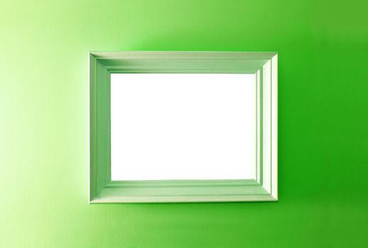 White empty frame on the green wall. Free copy space.