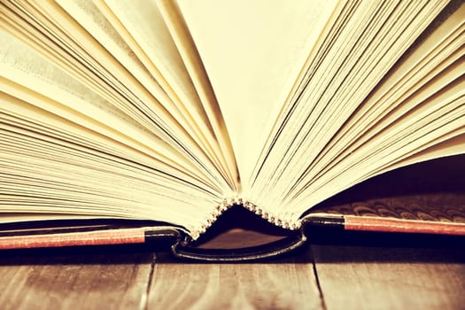 Open book on wooden table and white background. Education conceptual image.