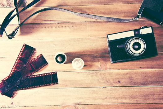 Retro vintage camera and photographic film on wooden background. Instagram retro vintage picture.