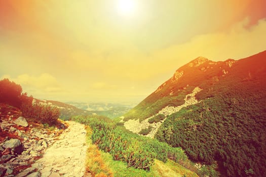 Colorfull mountains landscape. Retro instagram sunburst vintage picture.