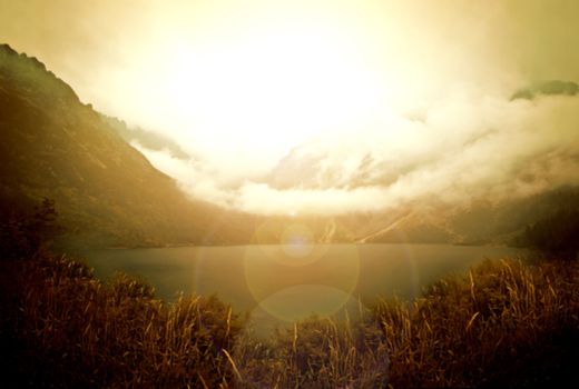 Bokeh abstract foggy mountains and lake landscape.