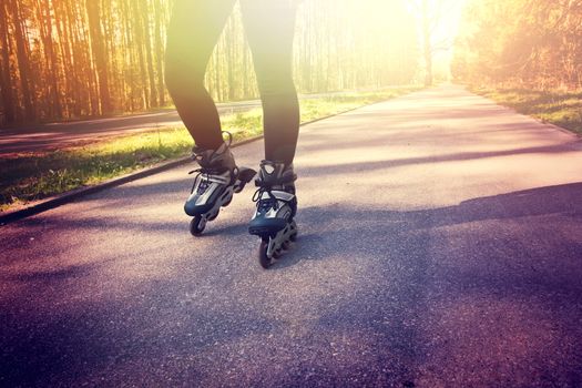 Teenage girl on roller skates at summer. Inline skates sport conceptual image.