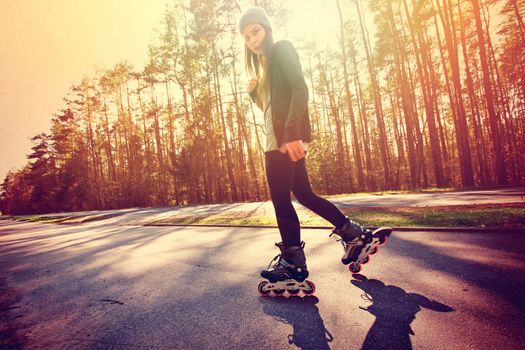 Teenage girl on roller skates at summer. Inline skates sport conceptual image.