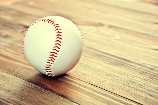 Baseball game. Baseball ball on wooden background. Vintage retro picture.