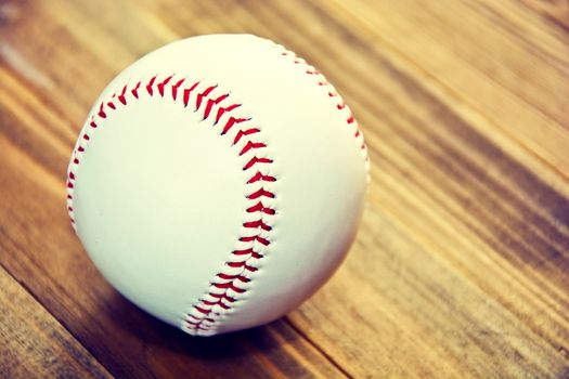 Baseball game. Baseball ball on wooden background. Vintage retro picture.
