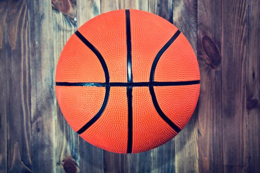 Basketball ball on wooden hardwood floor in the basketball court. Retro vintage picture. Sport concept.