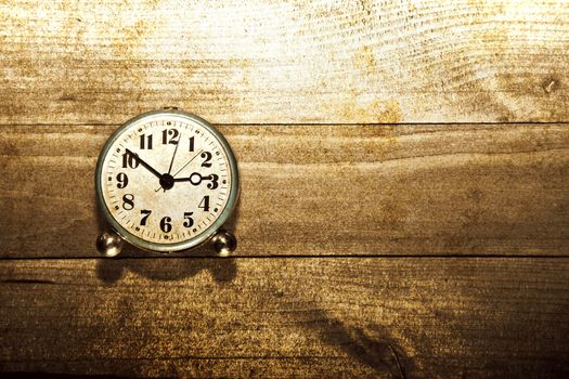 Old clock on the wooden background. Sepia grunge old stylized picture. Time concept.