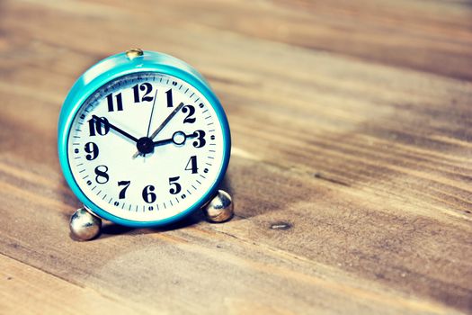 Old clock on the wooden background. Retro vintage picture. Time concept.