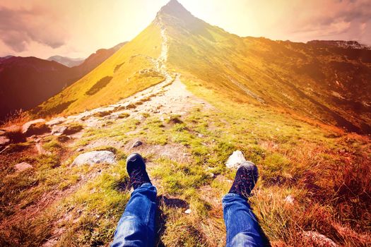 Tourism in mountains. Tourist rest on the mountain path. Nature in mountains at autumn.