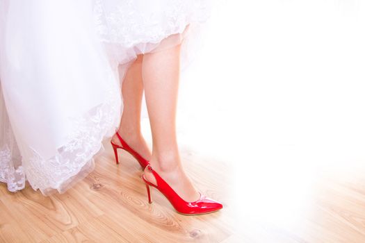 The bride in wedding dress and bridal shoes. Marriage and wedding concept image.