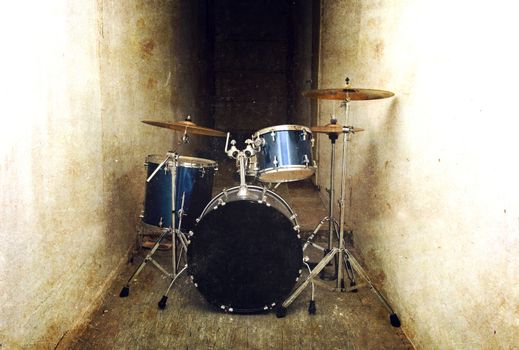 Drums conceptual image. Drum set percussion and cymbals in the dark corridor. Retro vintage grunge picture.