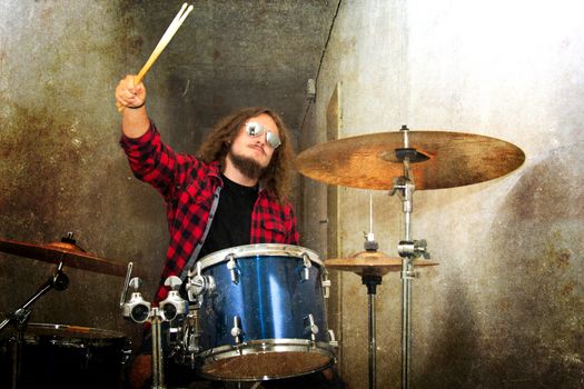 Drums conceptual image. Rock drummer holding drumsticks and playing on drums. Retro vintage grunge picture.