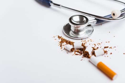 31 May of World No Tobacco Day, no smoking, close up of broken pile cigarette or tobacco and doctor stethoscope on white background with copy space, and Warning lung health concept