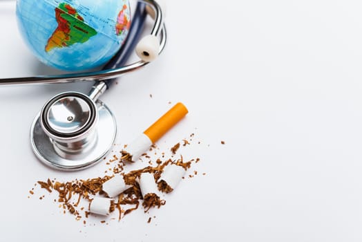 31 May of World No Tobacco Day, no smoking, close up of broken pile cigarette or tobacco and doctor stethoscope on white background with copy space, and Warning lung health concept