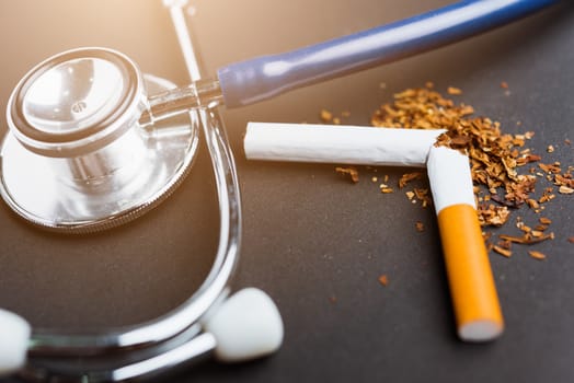 31 May of World No Tobacco Day, no smoking, close up of broken pile cigarette or tobacco and doctor stethoscope on black background with copy space, and Warning lung health concept
