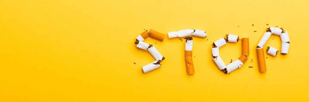 31 May of World No Tobacco Day, no smoking close up word STOP spelled text of the pile cigarette or tobacco on yellow background with banner copy space, and Warning lung health concept