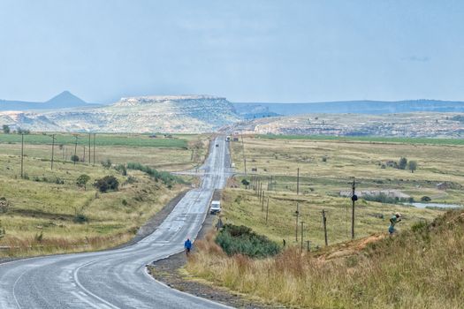 The landscape on road R26 to the south of Fouriesburg. People and vehicles are visible