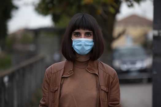 Close up portrait of a Girl with medical mask outdoor during covid quarantine in Italy