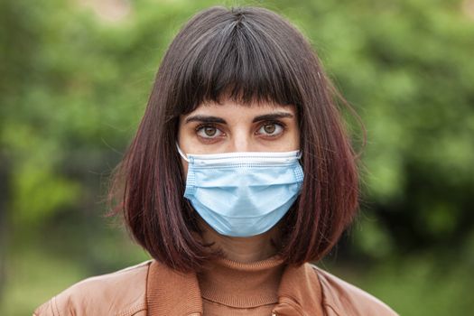 Close up Portrait of a Girl with medical mask outdoor during covid quarantine in Italy