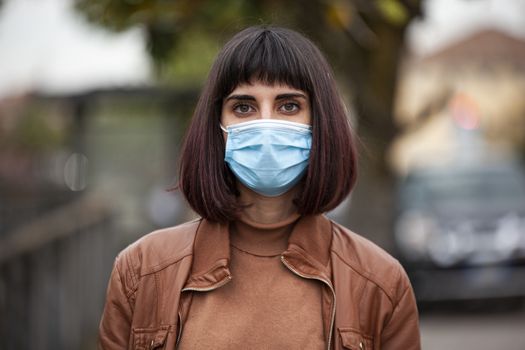 Close up portrait of a Girl with medical mask outdoor during covid quarantine in Italy