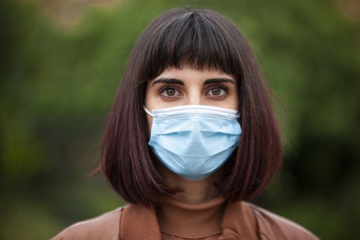 Close up Portrait of a Girl with medical mask outdoor during covid quarantine in Italy
