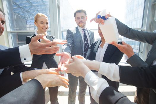 Business people team using hand sanitizer, healthcare and covid-19 prevention concept