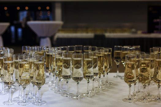 A group of glass bottles on a table with wine glasses. High quality photo