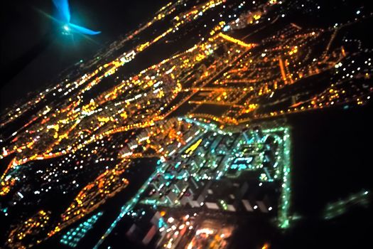 Defocused view from the airplane window of the city during the night. Aerial view of the city lights at night. Abstract of lights