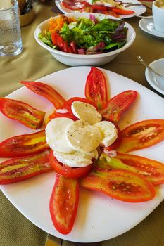 Traditional Italian Caprese Salad - sliced tomatoes, mozzarella cheese and basil