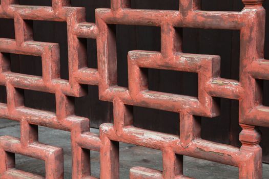 A closeup of old red weathered chinese wood work found in a garden in China.