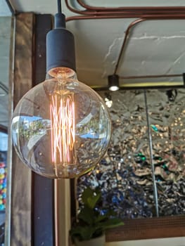 Electricity current inside a retro crystal clear light bulb.