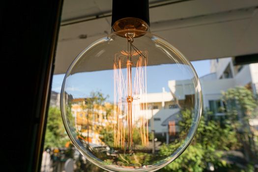 Electricity current inside a retro crystal clear light bulb.