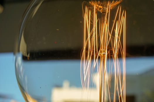 Electricity current inside a retro crystal clear light bulb.