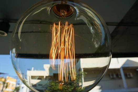 Electricity current inside a retro crystal clear light bulb.