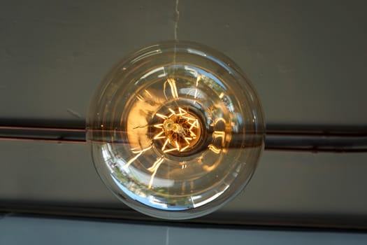 Electricity current inside a retro crystal clear light bulb.