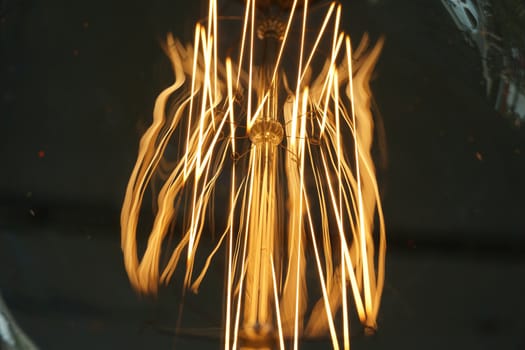 Amazing spiral electric current inside a retro crystal clear light bulb.