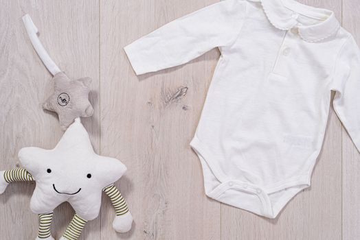 baby clothes concept. white suit for boy and girl on wooden background